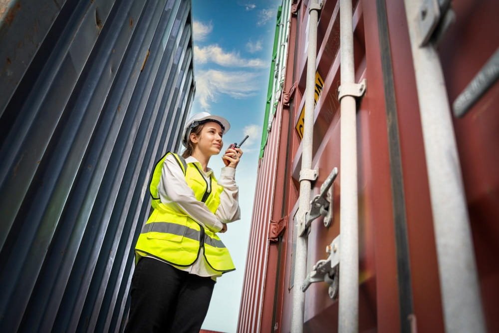 Profissional de logística realizando inspeção de contêineres em operação portuária